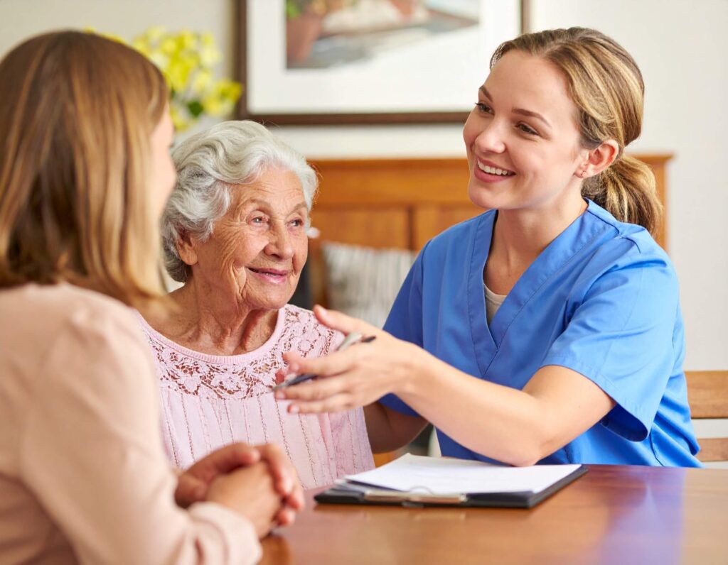 A nurse converses with an elderly woman, providing care and support in a warm, compassionate setting.