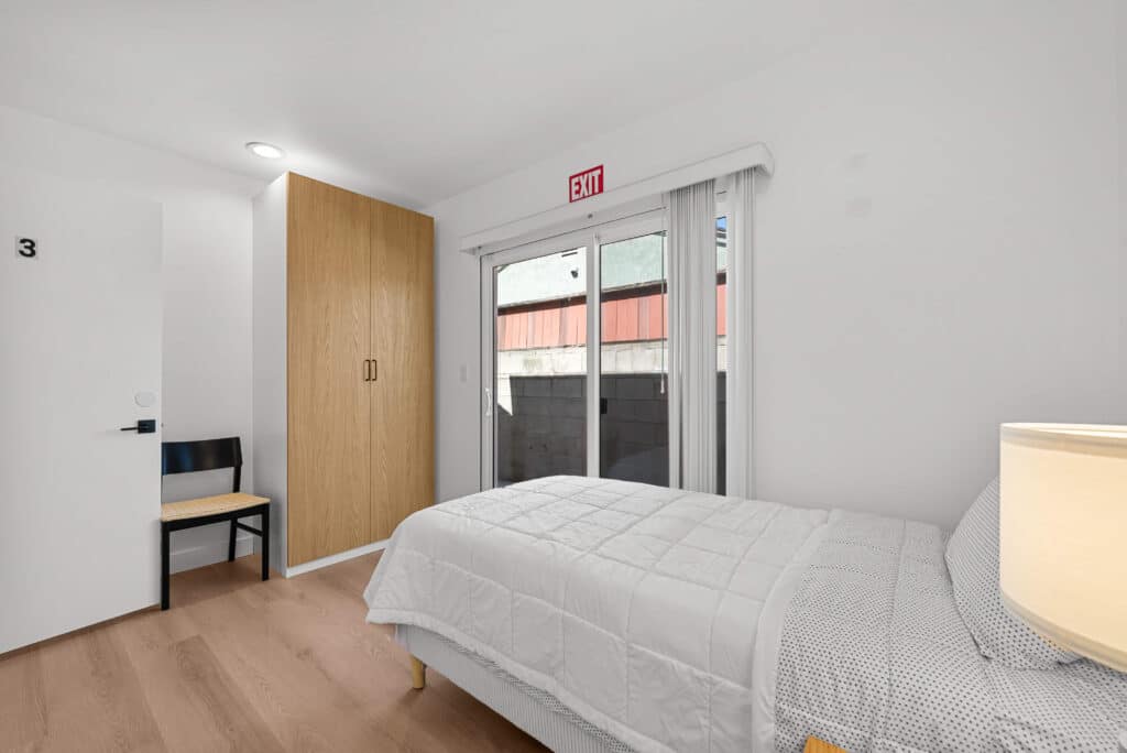 bedroom featuring a bed, a chair, and a sliding glass door leading to an outdoor space.