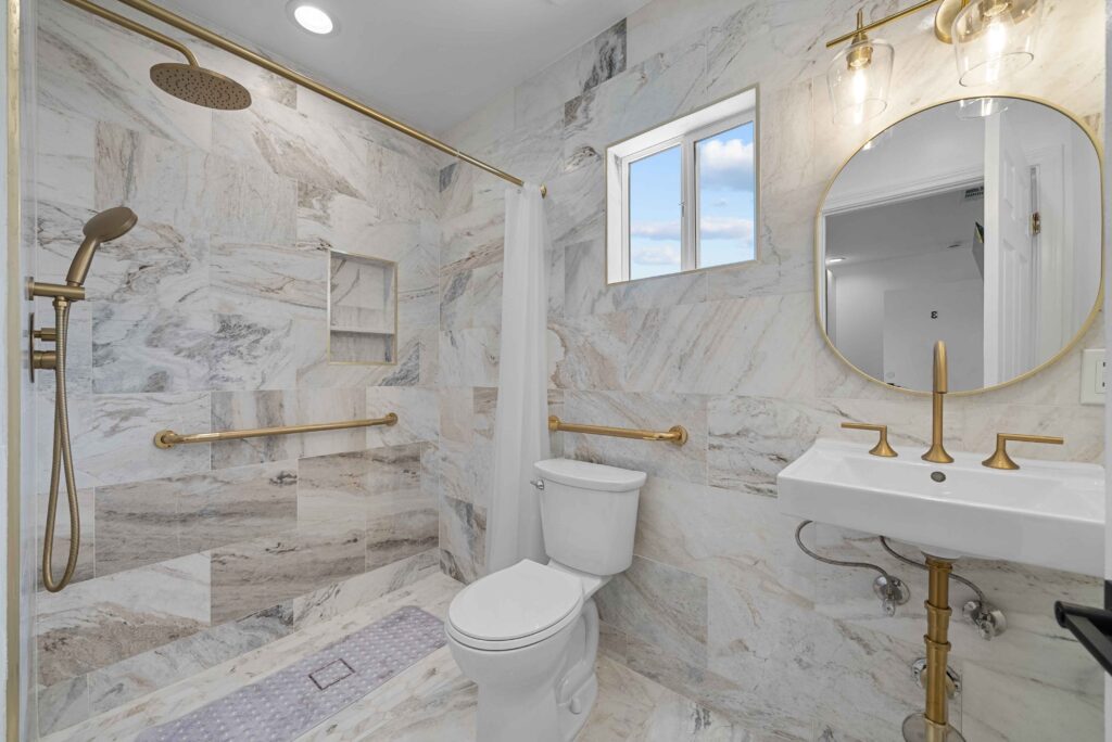 A luxurious bathroom featuring a marble floor and elegant gold fixtures.