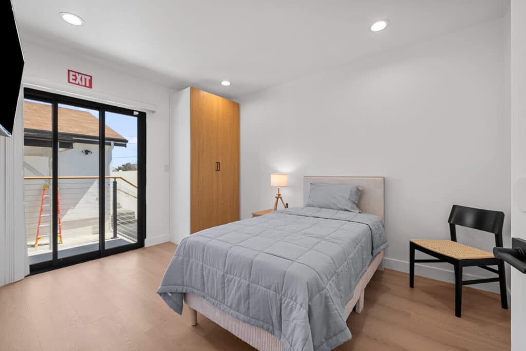 bedroom featuring a bed, a desk, and a sliding glass door leading to an outdoor space.