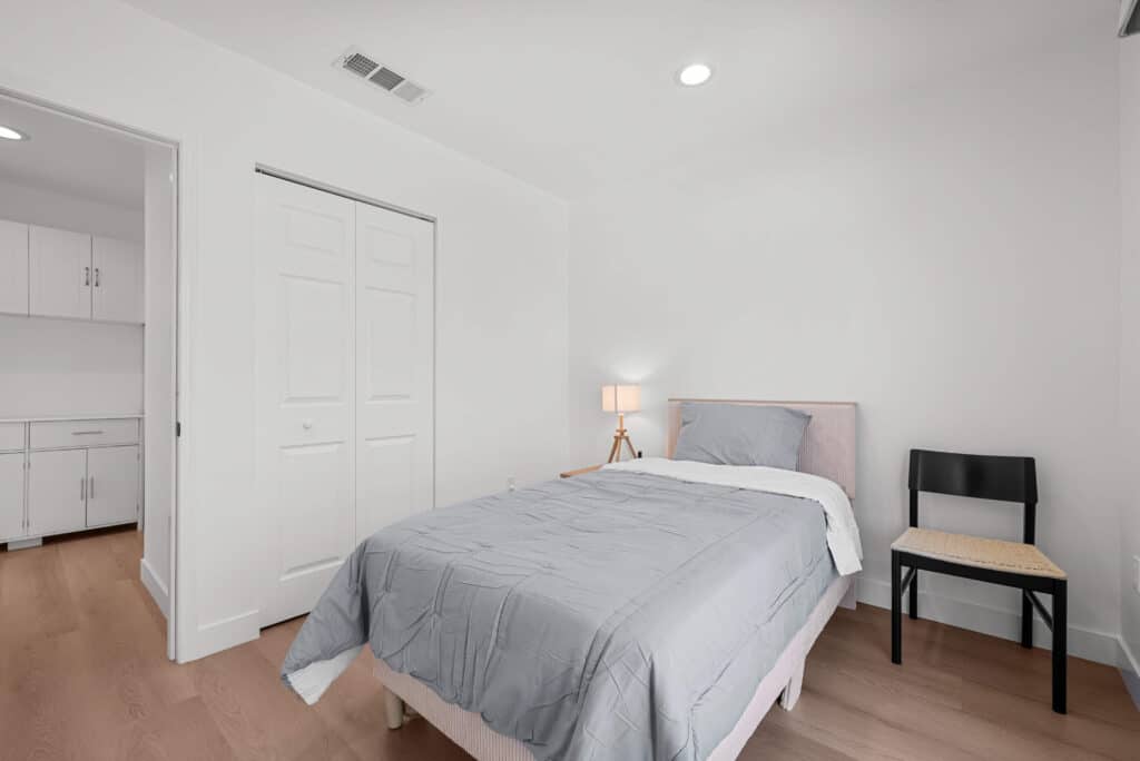 bedroom featuring a bed, a chair, and a closet, creating a comfortable and inviting atmosphere.