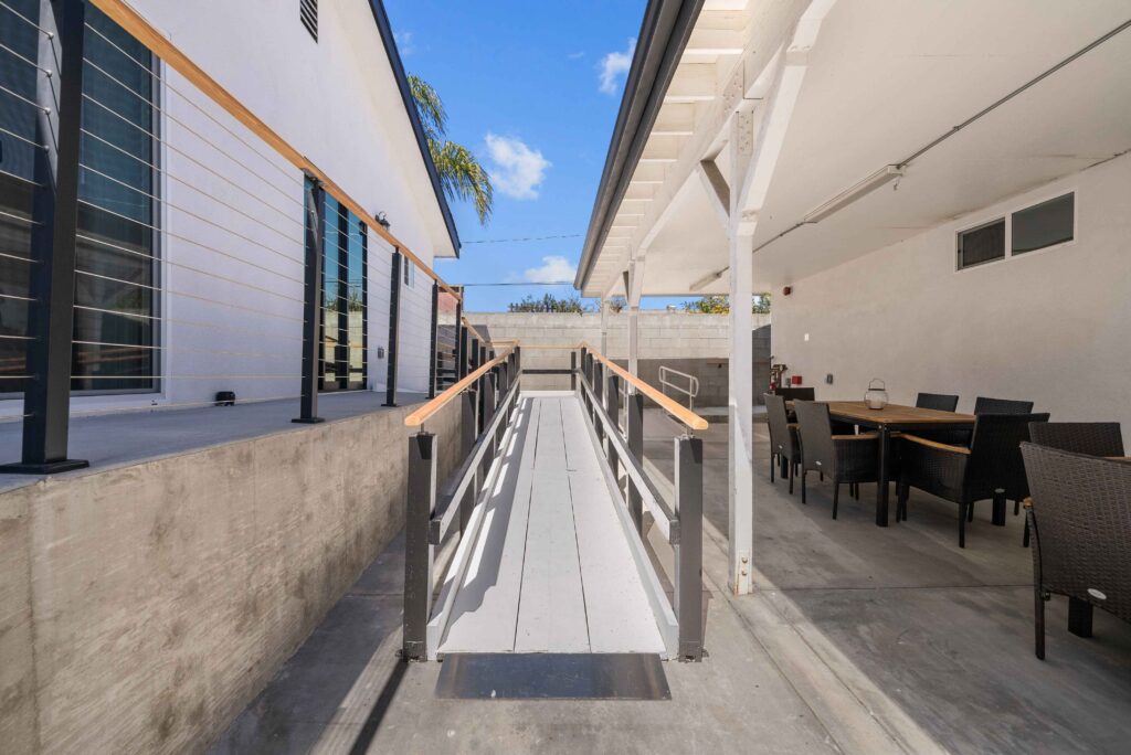 A patio featuring a table, chairs, and a wheelchair-accessible ramp for easy access.