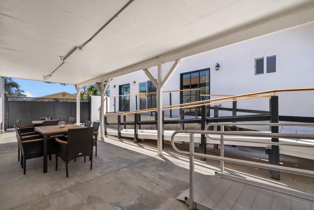 A patio featuring a table and chairs surrounded by a railing, ideal for outdoor dining and relaxation.