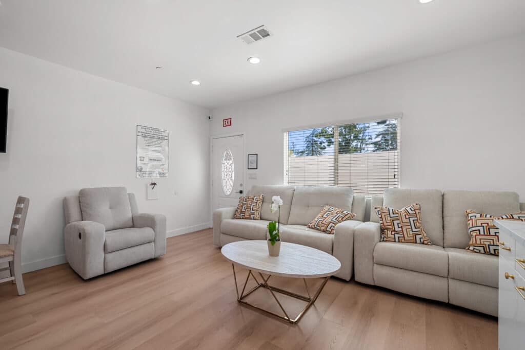 living room featuring two couches and a flat screen TV mounted on the wall.
