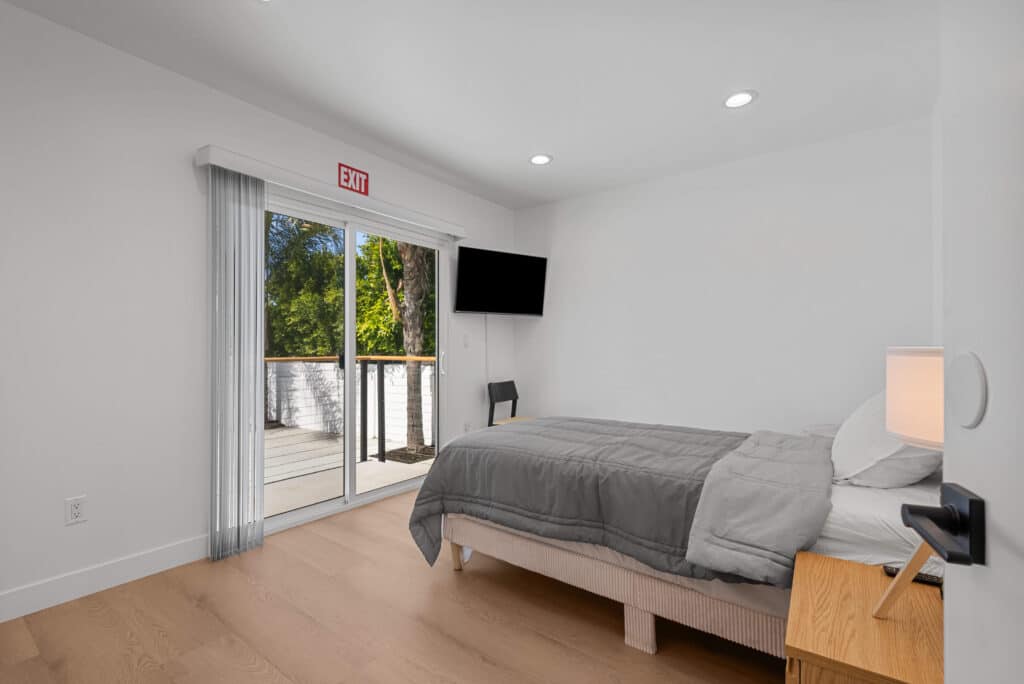 bedroom featuring a bed, a TV, and a sliding glass door leading to an outdoor space.