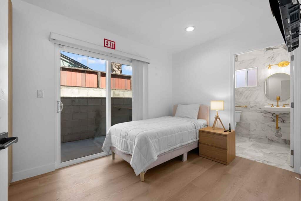 bedroom featuring a bed, a sink, and a sliding glass door leading to an outdoor space.