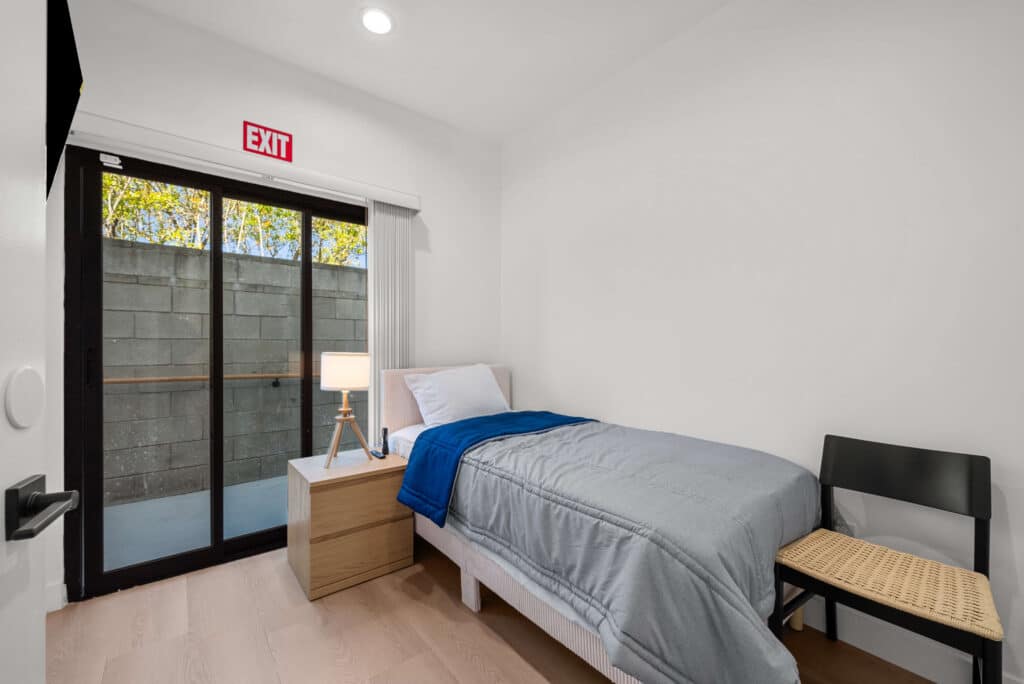 bedroom featuring a bed, a TV, and a sliding glass door leading to an outdoor space.